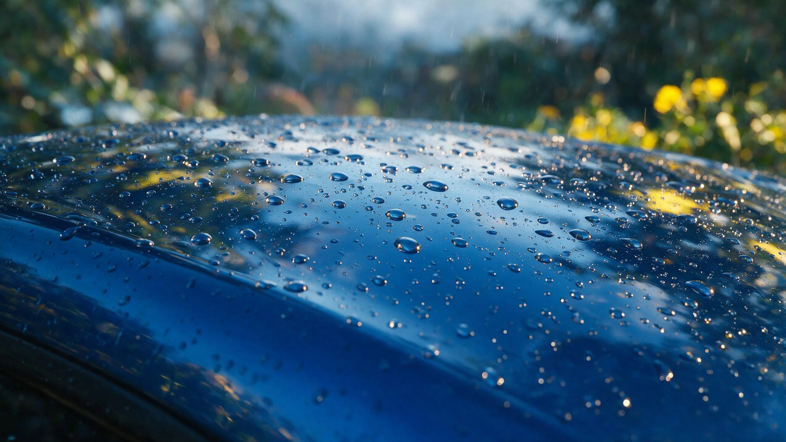 Quanto custa proteção pintura carro: gotas de chuva sobre capô com revestimento hidrofóbico